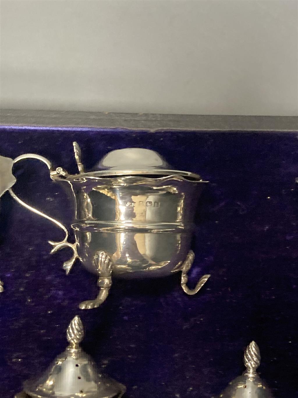 An Edwardian cased seven piece silver condiment set, Birmingham, 1907, (lacking spoons).